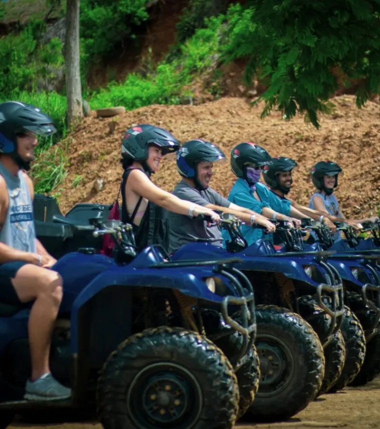 Riders in helmets on a row of ATVs