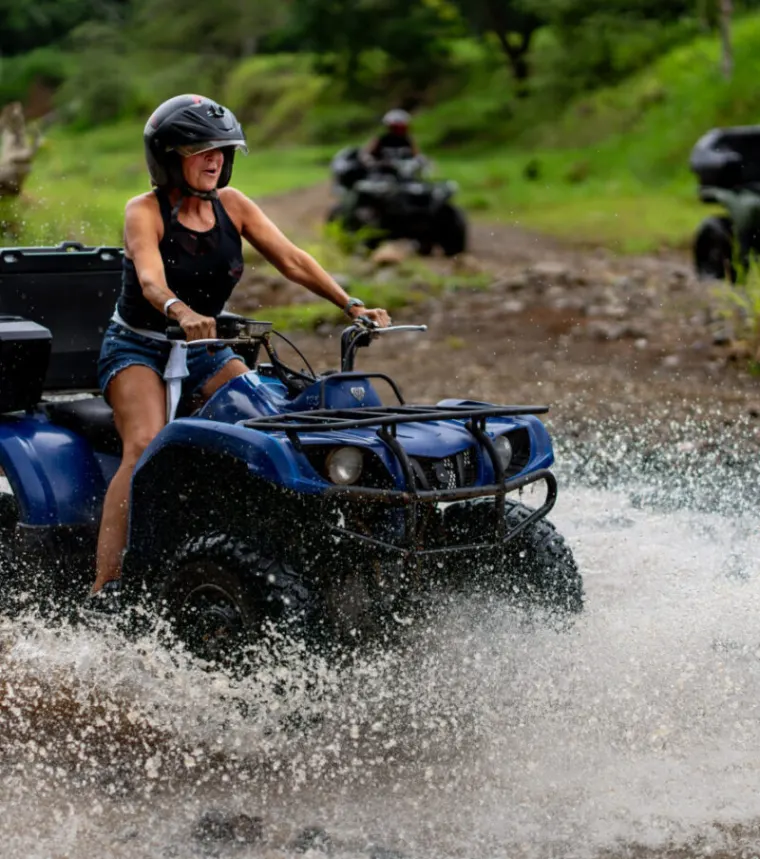 An ATV splashing through the river